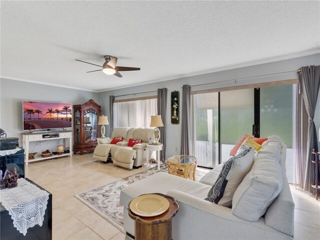 living room with light tile patterned floors, a textured ceiling, ceiling fan, and ornamental molding