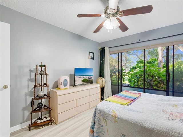 bedroom featuring a textured ceiling, light hardwood / wood-style flooring, and ceiling fan