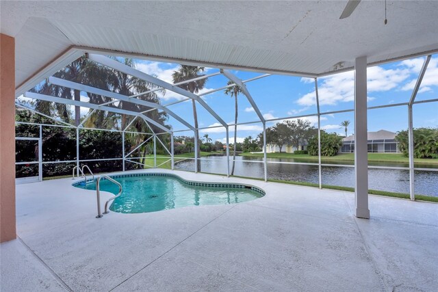 pool featuring a lanai, a patio, and a water view