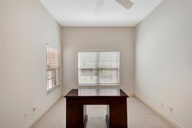 unfurnished office featuring baseboards, carpet, and ceiling fan