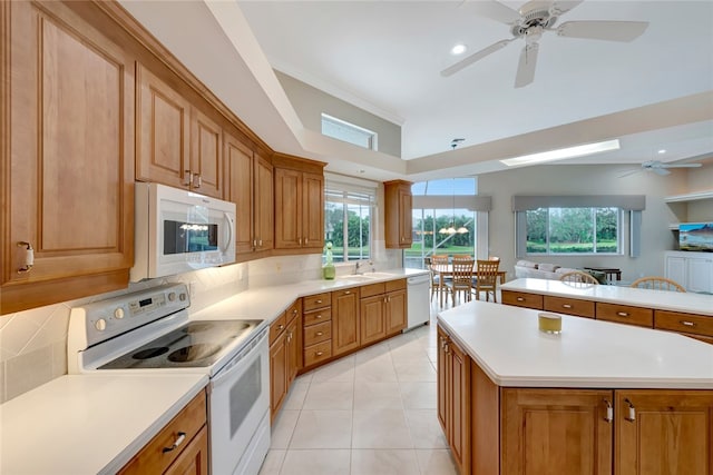 kitchen with light countertops, decorative backsplash, light tile patterned flooring, white appliances, and a sink