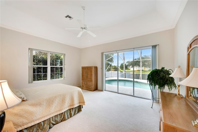 bedroom with access to exterior, visible vents, light carpet, and a tray ceiling