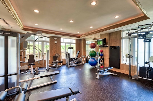 workout area featuring a tray ceiling, crown molding, and recessed lighting