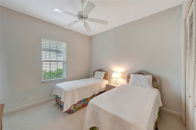 carpeted bedroom featuring baseboards, a closet, and ceiling fan