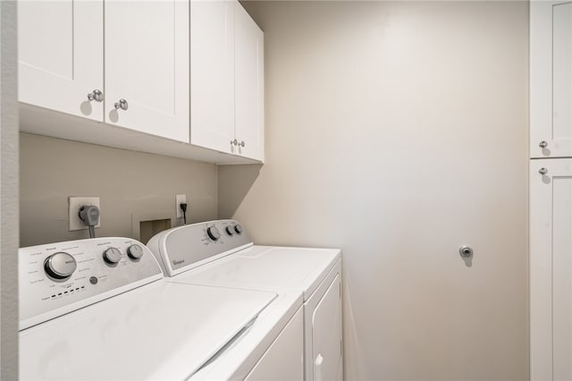 laundry area with washing machine and clothes dryer and cabinets