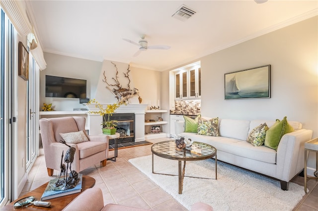 tiled living room with ceiling fan and ornamental molding