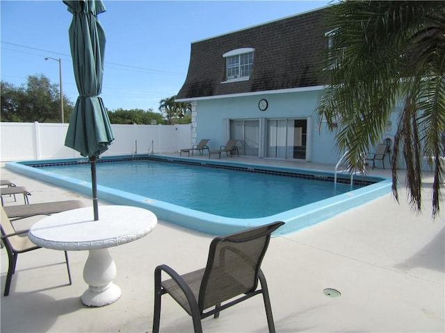 view of pool with a patio and an outdoor structure