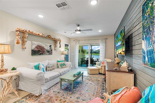 living room with a textured ceiling, visible vents, a ceiling fan, and recessed lighting