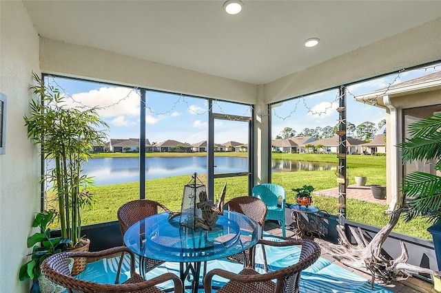 sunroom featuring a water view