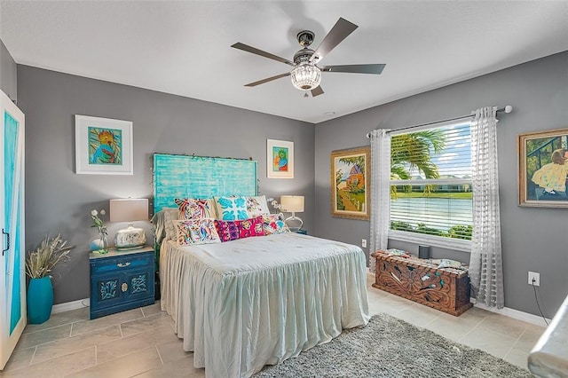 bedroom featuring baseboards, a ceiling fan, and light tile patterned flooring