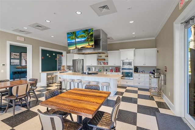 kitchen with stainless steel appliances, ornamental molding, light floors, and light countertops