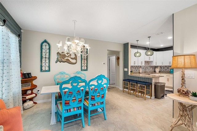 dining space featuring a chandelier, visible vents, and baseboards