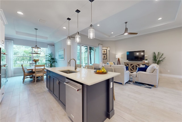 kitchen with stainless steel dishwasher, a wealth of natural light, sink, and decorative light fixtures