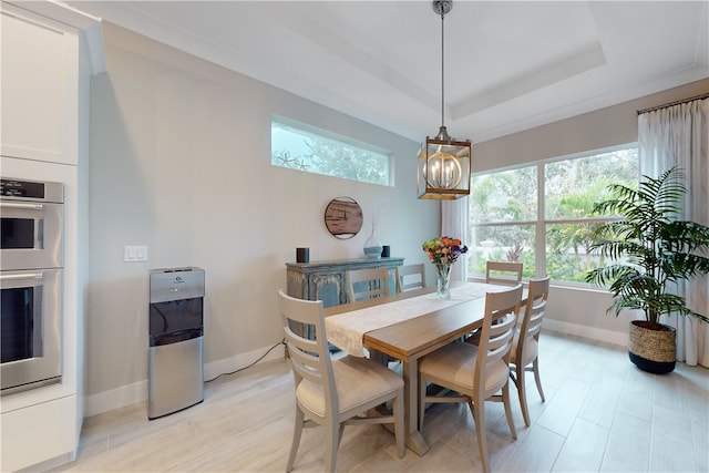 dining room with plenty of natural light, a raised ceiling, and an inviting chandelier