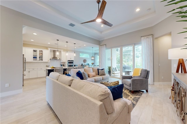 living room featuring light hardwood / wood-style floors and a raised ceiling