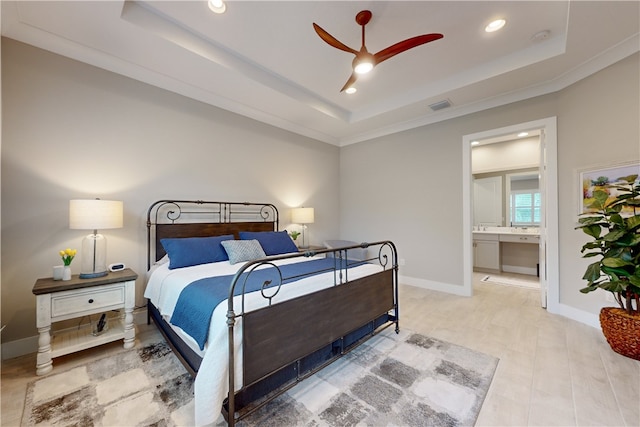 bedroom featuring ceiling fan, connected bathroom, a raised ceiling, and ornamental molding