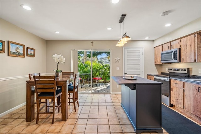 kitchen featuring a kitchen island, appliances with stainless steel finishes, pendant lighting, a breakfast bar area, and light tile patterned floors