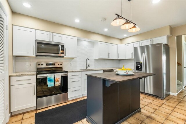 4019 Silver Palm Dr Unit 8, Vero Beach, FL 32963 - kitchen with white cabinets, stainless steel appliances, a sink, light tile patterned flooring, and decorative backsplash