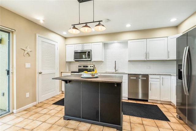 4019 Silver Palm Dr Unit 8, Vero Beach, FL 32963 - kitchen featuring white cabinets, a sink, decorative backsplash, appliances with stainless steel finishes, and light tile patterned floors