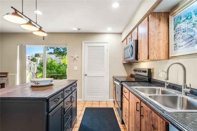 kitchen featuring sink, a center island, hanging light fixtures, light tile patterned floors, and stainless steel appliances