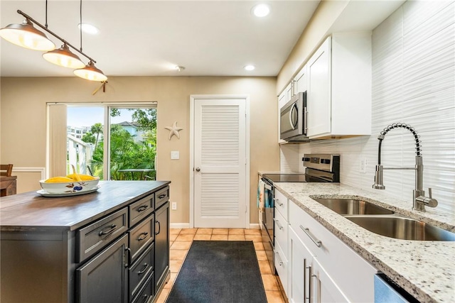 4019 Silver Palm Dr Unit 8, Vero Beach, FL 32963 - kitchen featuring a sink, light tile patterned floors, stainless steel appliances, white cabinetry, and recessed lighting