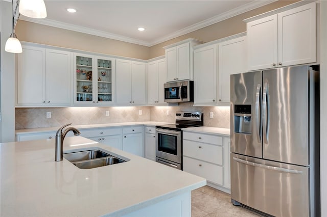 kitchen featuring pendant lighting, stainless steel appliances, white cabinetry, and sink