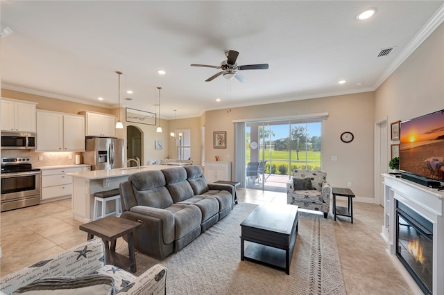 tiled living room featuring ceiling fan and ornamental molding