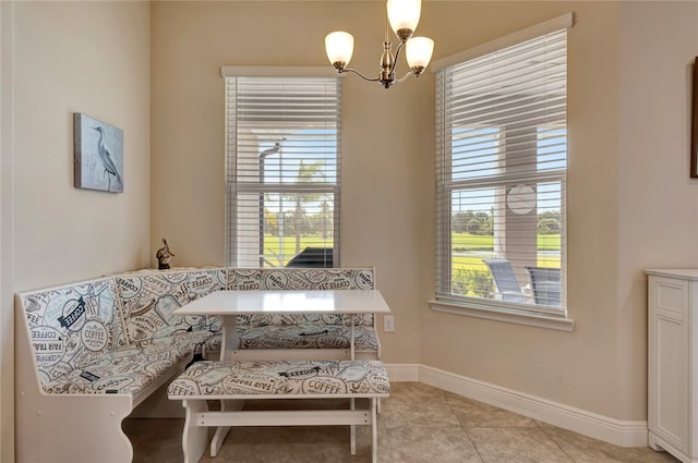 living area with light tile patterned floors, breakfast area, and a notable chandelier