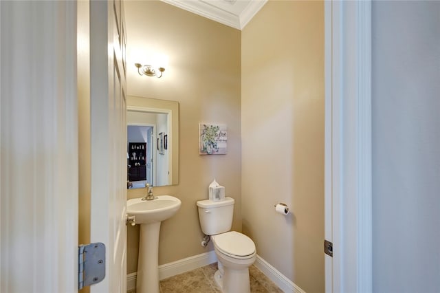 bathroom featuring tile patterned flooring, toilet, ornamental molding, and sink