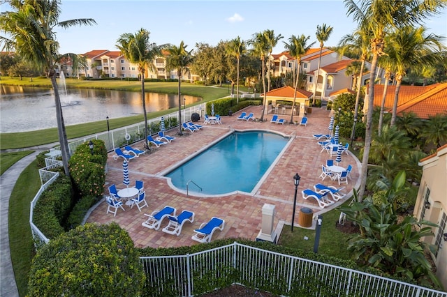 view of swimming pool featuring a water view and a patio