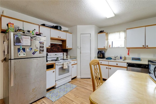 kitchen featuring white cabinets, appliances with stainless steel finishes, a textured ceiling, and light wood-type flooring