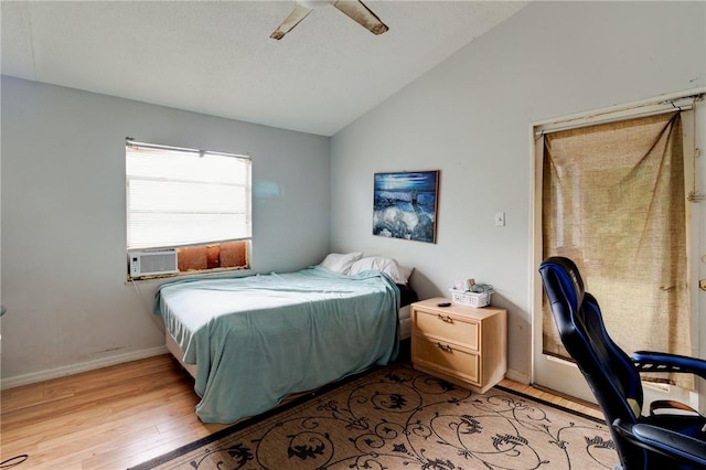 bedroom with cooling unit, ceiling fan, vaulted ceiling, and light hardwood / wood-style flooring