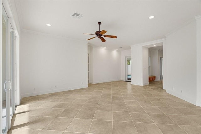 spare room with crown molding, visible vents, ceiling fan, and baseboards