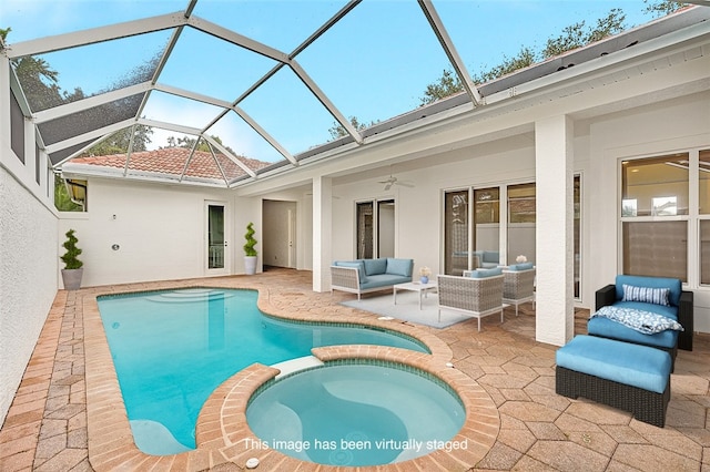 view of pool with glass enclosure, ceiling fan, an outdoor hangout area, a patio area, and an in ground hot tub