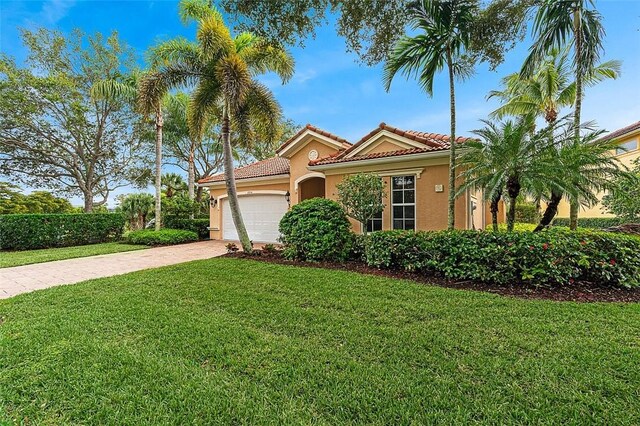 mediterranean / spanish-style house with a garage and a front yard