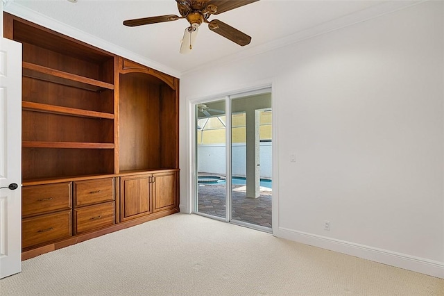 carpeted empty room with ceiling fan and crown molding