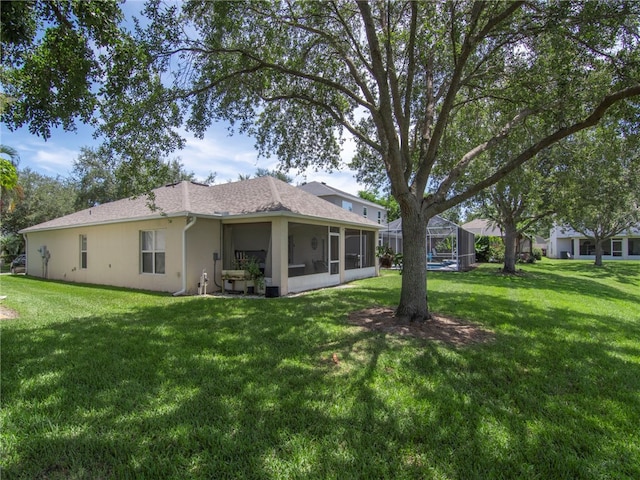 2540 12th Sq SW, Vero Beach, FL 32968 - rear view of house with a yard, stucco siding, a sunroom, and a shingled roof