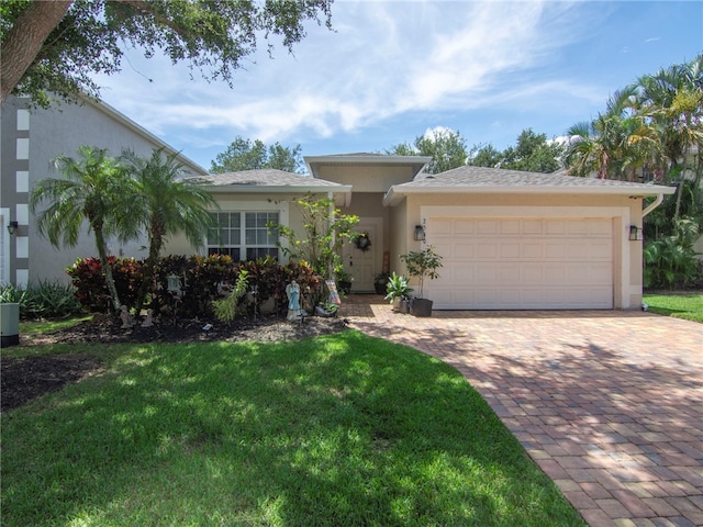 2540 12th Sq SW, Vero Beach, FL 32968 - view of front of home with stucco siding, a front lawn, an attached garage, and decorative driveway