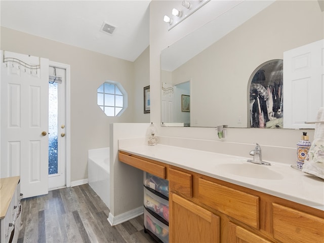 2540 12th Sq SW, Vero Beach, FL 32968 - bathroom with vanity, a bath, and wood finished floors