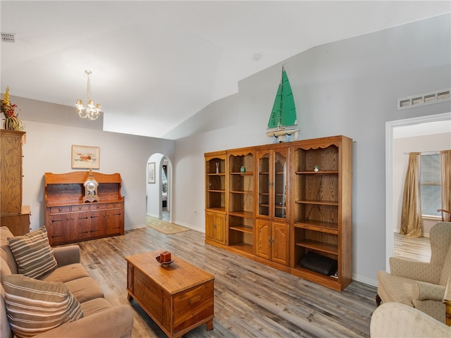 2540 12th Sq SW, Vero Beach, FL 32968 - living area with vaulted ceiling, arched walkways, a chandelier, and wood finished floors