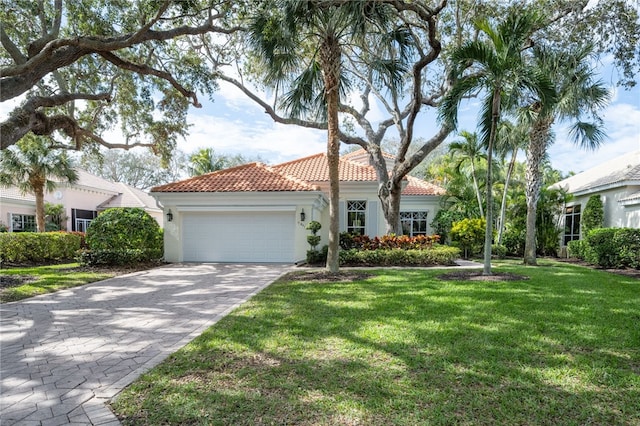 mediterranean / spanish-style home featuring a front yard and a garage