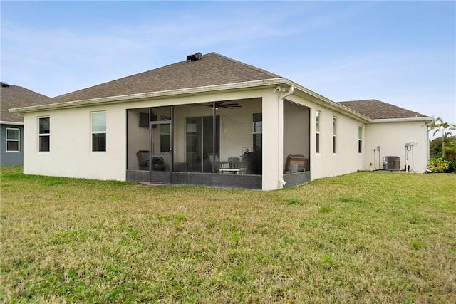 rear view of property featuring central AC unit, a lawn, and a sunroom