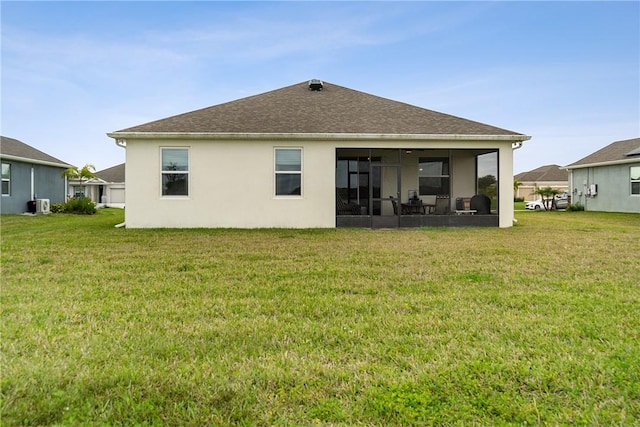 back of house featuring a lawn and a sunroom