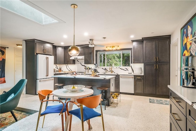 3050 11th Ave, Vero Beach, FL 32960 - kitchen with white appliances, dark brown cabinetry, light countertops, a skylight, and recessed lighting