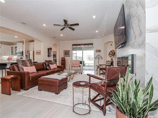 living room featuring ceiling fan and crown molding