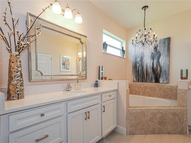 bathroom with vanity, tiled tub, tile patterned flooring, and an inviting chandelier