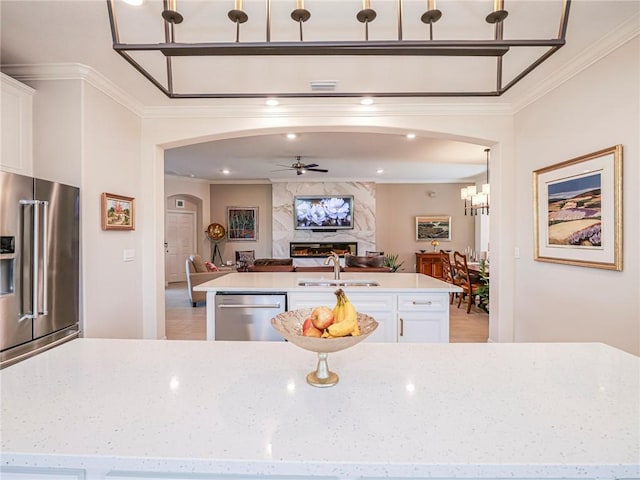 kitchen featuring sink, stainless steel appliances, ornamental molding, and white cabinetry