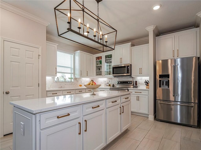 kitchen with decorative light fixtures, stainless steel appliances, glass insert cabinets, white cabinetry, and a kitchen island