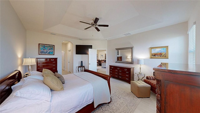 bedroom featuring a raised ceiling and ceiling fan