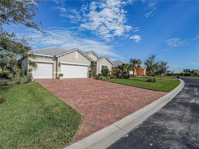 ranch-style home featuring a garage, stucco siding, decorative driveway, and a front yard